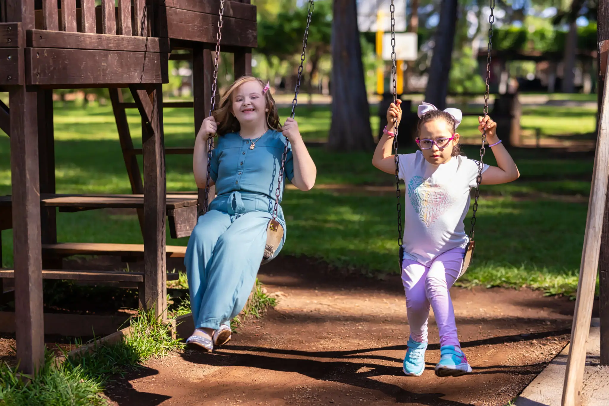 Two girls swinging in a park