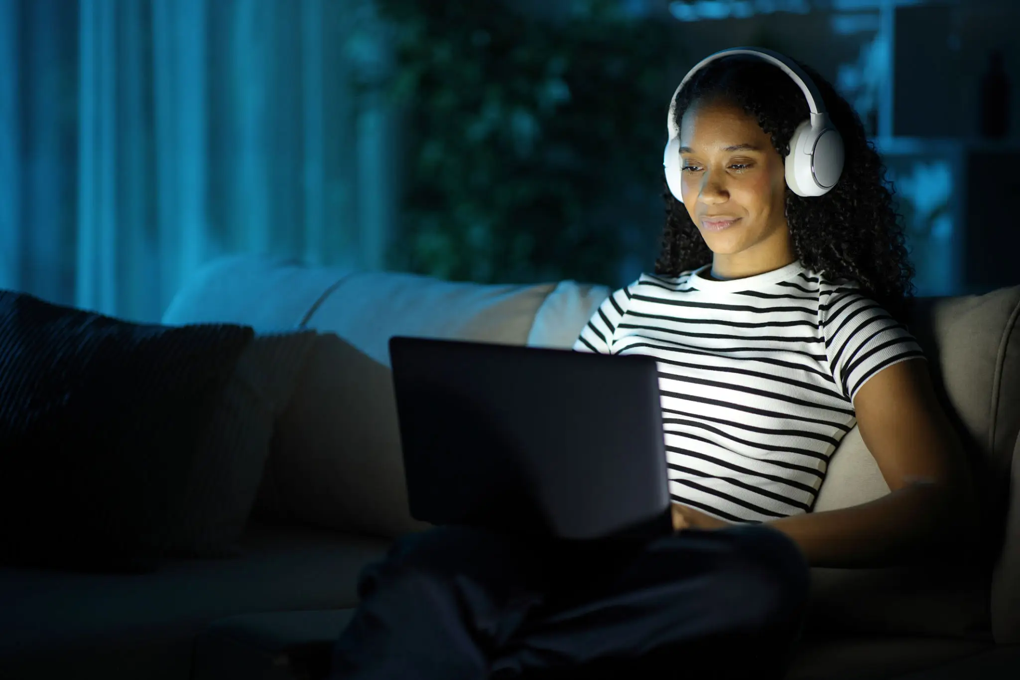 Woman wearing headphones using a laptop